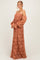 woman wearing a rust-colored off-shoulder maxi dress with puff sleeves and floral lace details