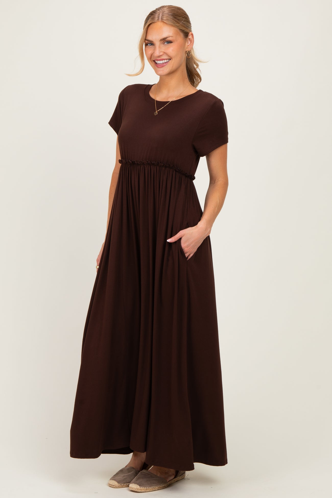 woman wearing a chocolate brown short sleeve maxi dress with a gathered waist and pockets