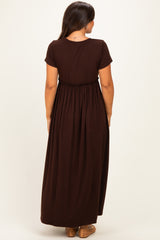 woman wearing a brown maternity maxi dress with short sleeves and an elastic waistband viewed from the back