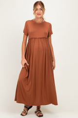 woman wearing a rust brown short sleeve maternity maxi dress, showing her baby bump