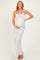 woman wearing a light beige floral print maternity maxi dress and holding her baby bump