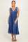 woman wearing a blue sleeveless maxi dress with a deep V-neck and a flowing skirt