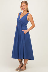 woman wearing a navy blue midi dress with a deep v-neck and pockets, styled with espadrille sandals