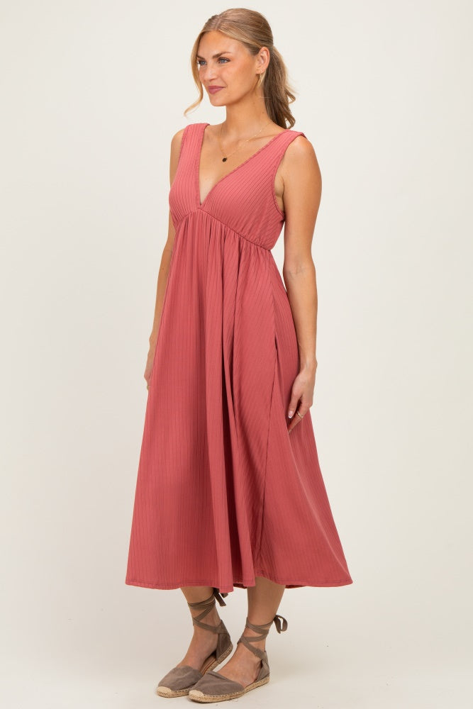 woman wearing a rose colored sleeveless midi dress with a v-neck and a flowy skirt