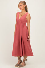 woman wearing a rose colored sleeveless midi dress with a v-neck and a flowy skirt