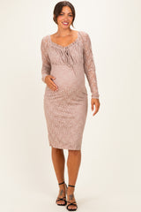 woman wearing a blush lace long sleeve maternity dress with a fitted silhouette and a visible baby bump