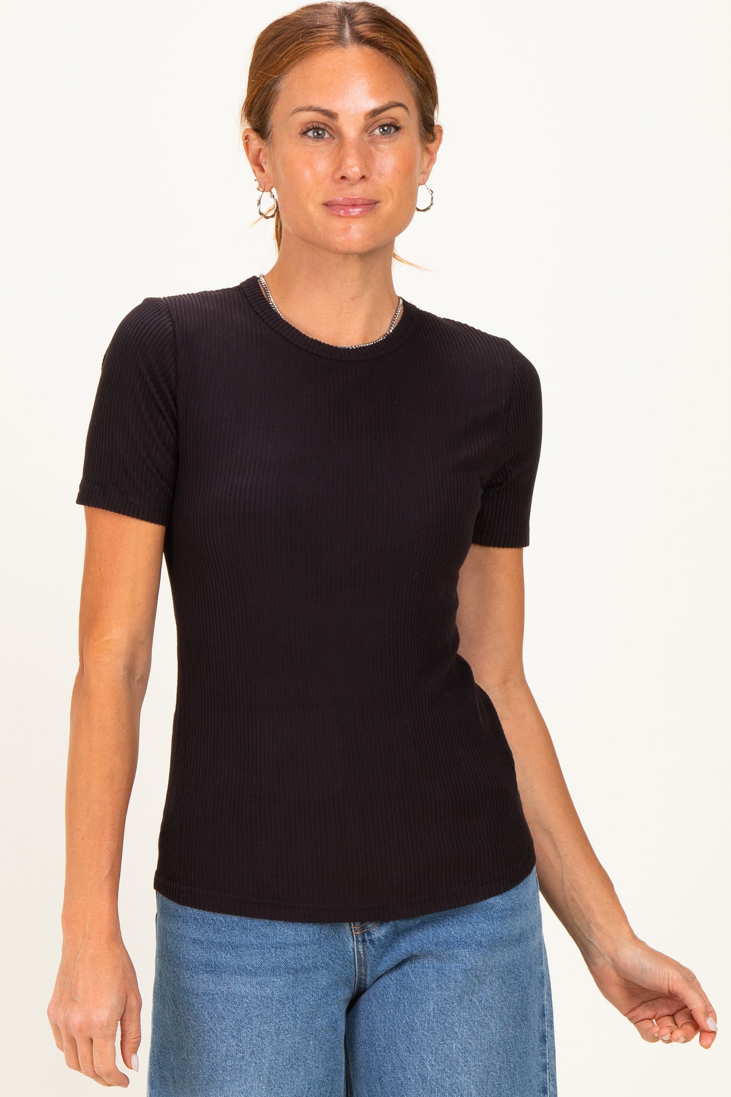woman wearing a black short sleeve ribbed top and blue jeans