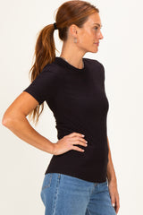 woman wearing a fitted black ribbed t-shirt paired with high-waisted blue jeans