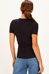 woman wearing a black fitted ribbed short sleeve top with a round neckline paired with light blue jeans
