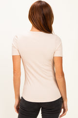 woman wearing a light pink ribbed short sleeve top, shown from the back with a fitted silhouette