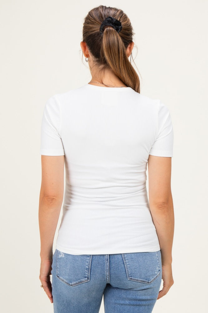 woman wearing a fitted white short sleeve maternity top, seen from the back, paired with blue jeans