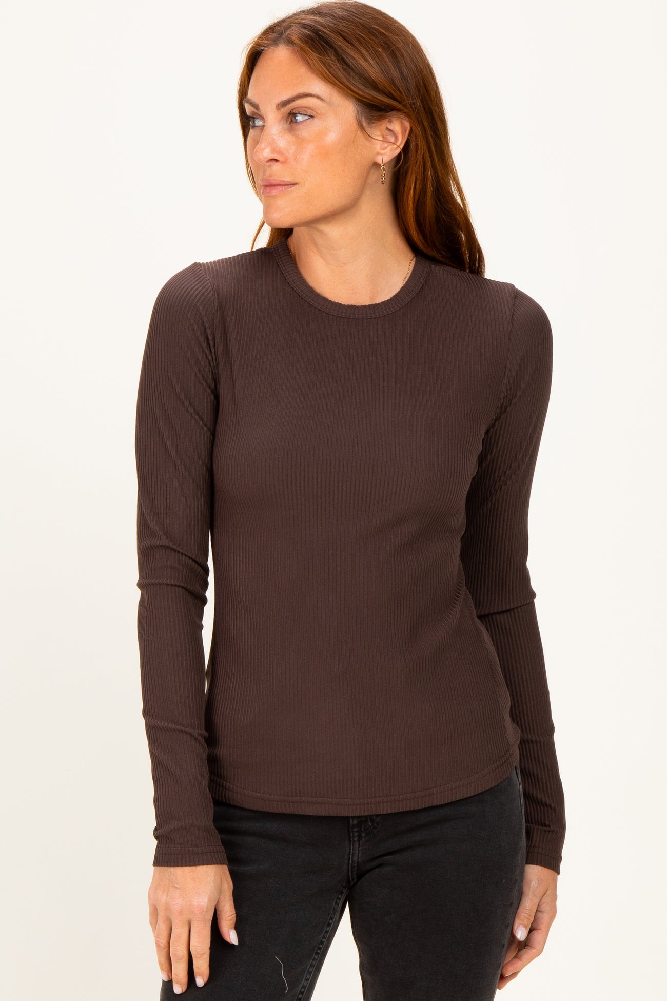 woman wearing a dark brown long sleeve ribbed top with a fitted silhouette and round neckline