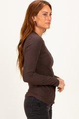 woman wearing a brown ribbed long sleeve top paired with black jeans