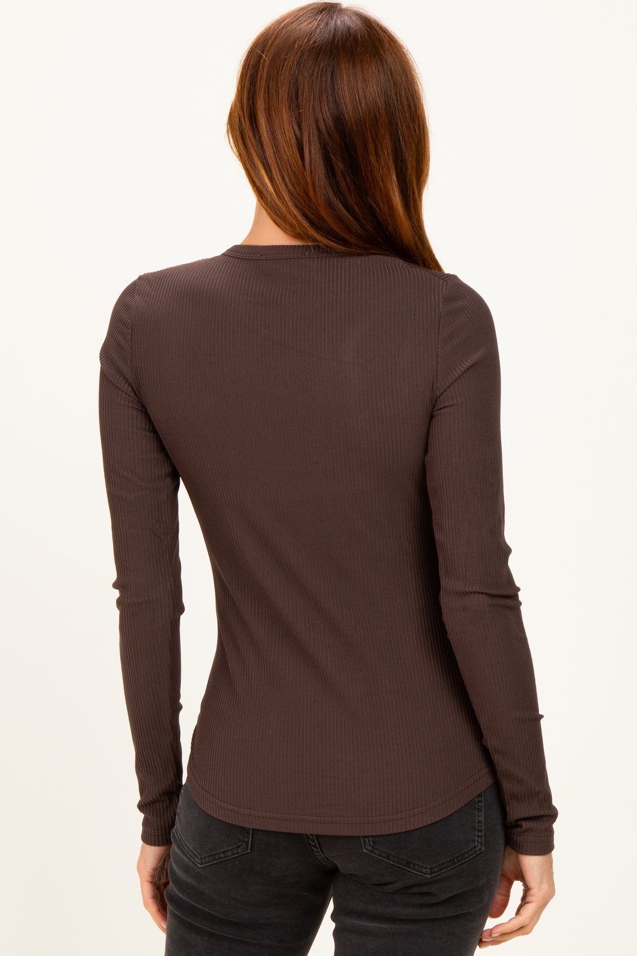 woman wearing a dark brown long sleeve ribbed top, viewed from the back
