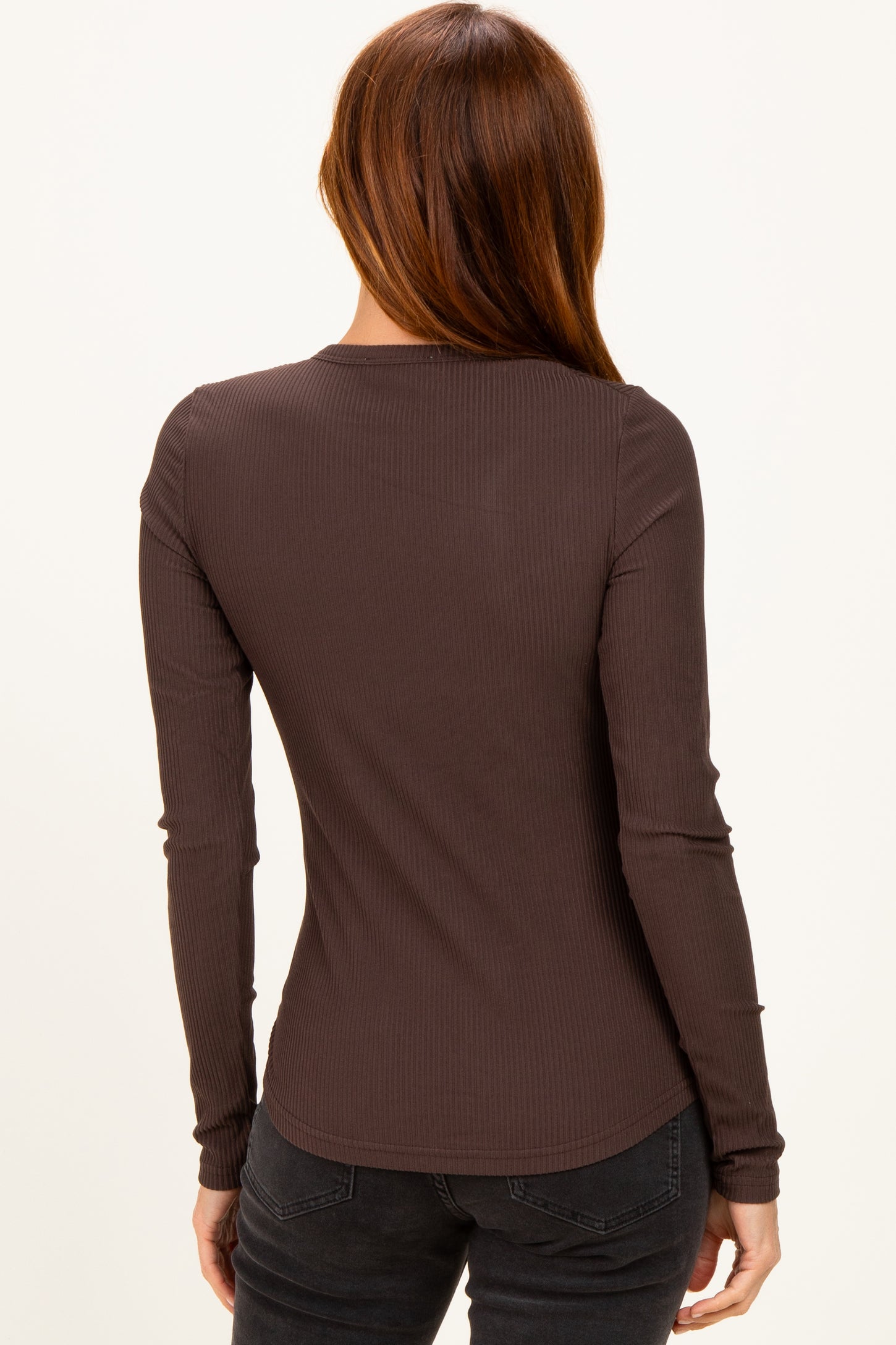 woman wearing a dark brown long sleeve ribbed top, viewed from the back