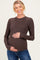 woman wearing a brown long sleeve maternity top and holding her baby bump