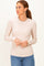 woman wearing a beige long sleeve ribbed top paired with blue jeans
