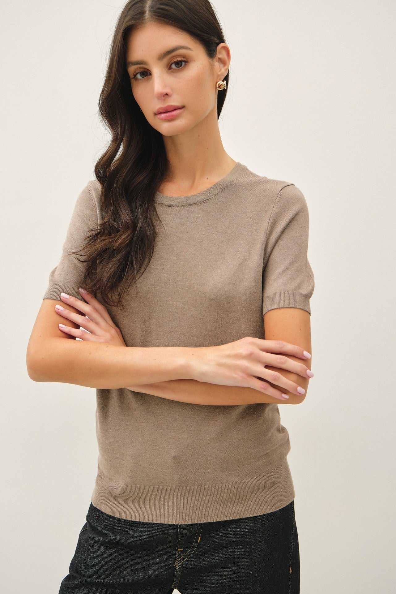 woman wearing a taupe short sleeve knit sweater with a classic crew neck and relaxed fit