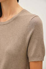 woman wearing a taupe short sleeve knit sweater with a round neckline and soft texture