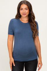 woman wearing a soft blue short sleeve maternity top and showing her baby bump