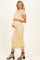 woman wearing a yellow lace maternity dress and holding her baby bump