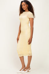 woman wearing a yellow lace midi dress with short sleeves and a fitted silhouette