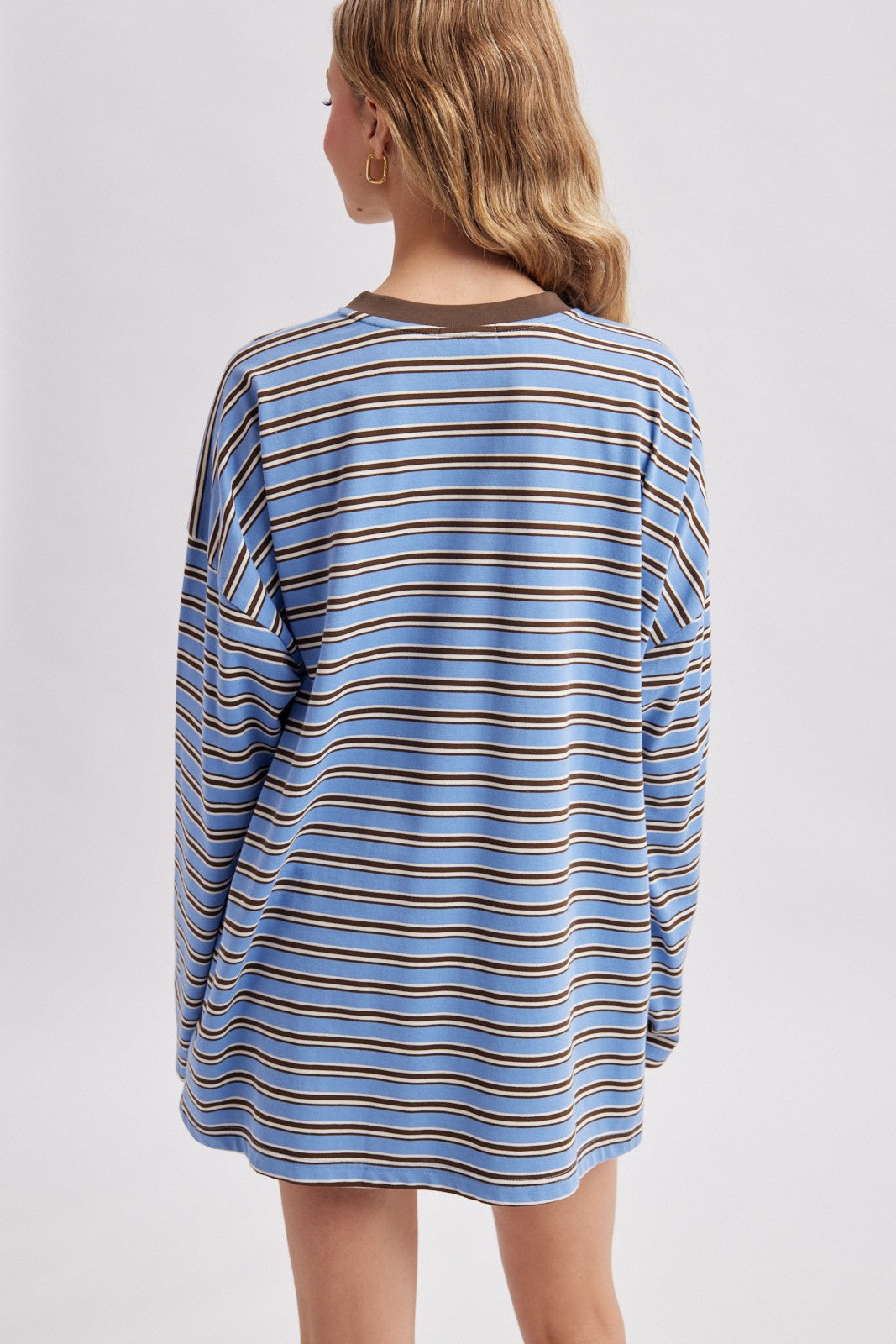 woman wearing a blue and brown striped oversized long sleeve shirt, viewed from the back