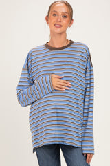 woman wearing a blue and brown striped long sleeve maternity top and holding her baby bump