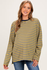 woman wearing a mustard striped maternity top with long sleeves, smiling and showing her baby bump