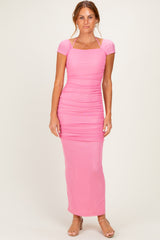 woman wearing a pink ruched maxi dress with short sleeves and a square neckline