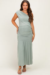 woman wearing a sage green one-shoulder maternity gown with ruching and a flared bottom, showcasing a baby bump