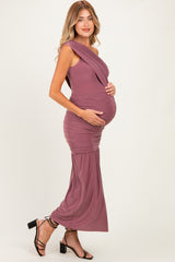 woman wearing a mauve one-shoulder maternity gown highlighting her baby bump