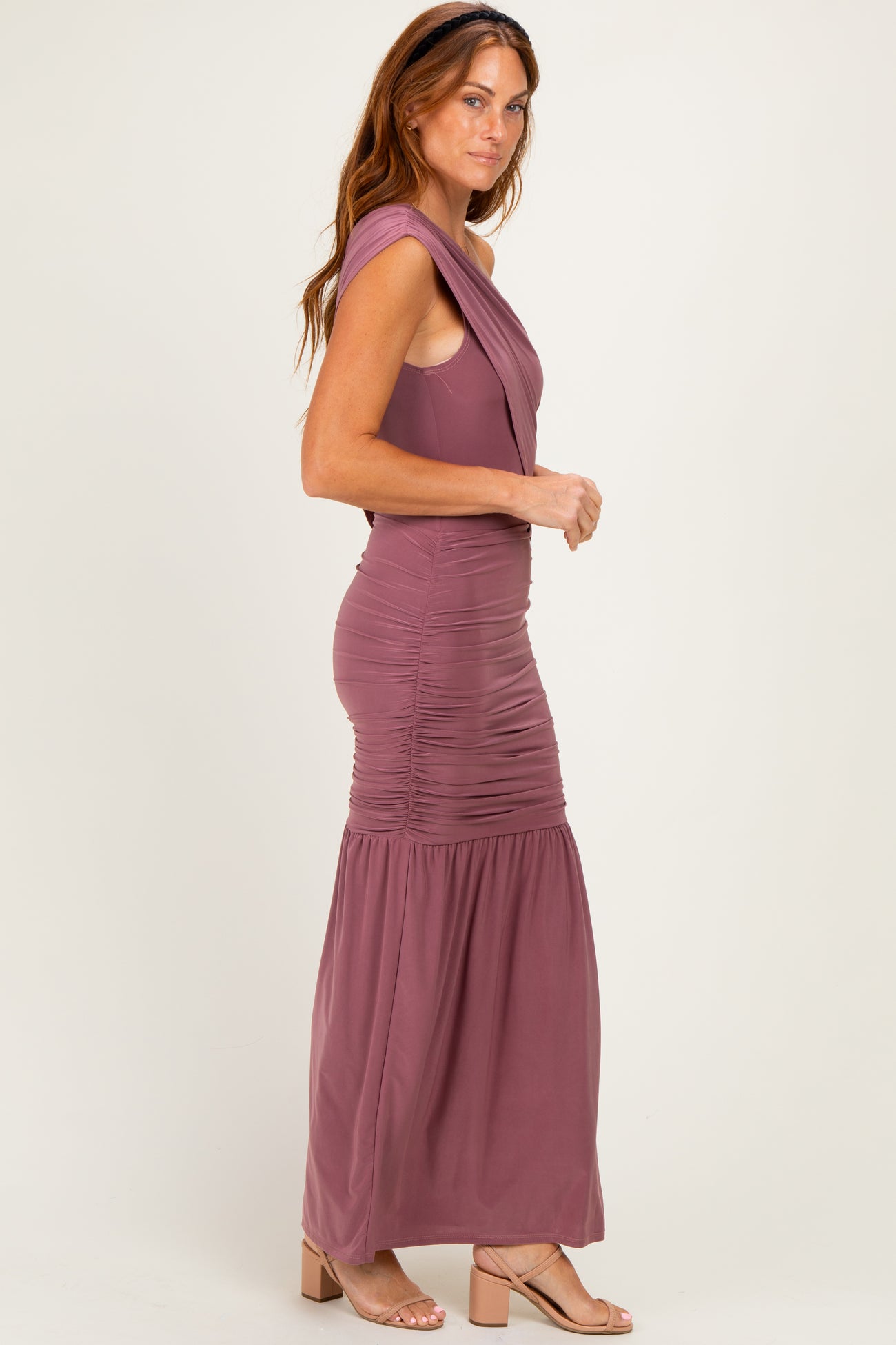 woman wearing a mauve sleeveless maxi dress with ruched detailing and a flared skirt