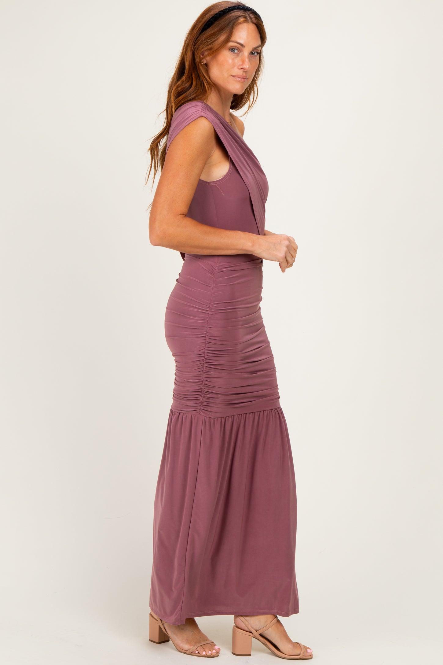 woman wearing a mauve sleeveless maxi dress with ruched detailing and a flared skirt