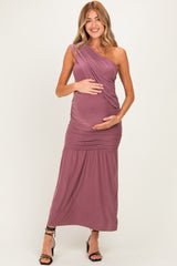 woman wearing a mauve one-shoulder maternity dress, highlighting her baby bump with a ruched design