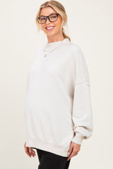 woman wearing a light grey maternity sweatshirt with a relaxed fit and a visible baby bump