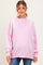 woman wearing a pink oversized maternity sweatshirt with distressed details and a visible baby bump