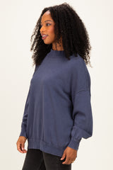 woman wearing a navy blue oversized sweatshirt with long sleeves and a relaxed fit