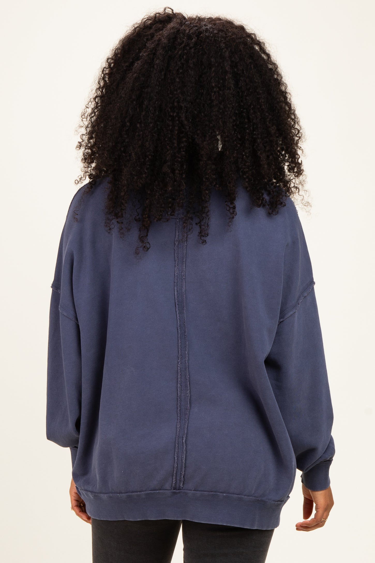 woman wearing a navy oversized sweatshirt with a relaxed fit and back seam detail