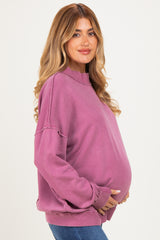 woman wearing a purple maternity sweatshirt with a relaxed fit and holding her baby bump