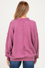 woman wearing a mauve oversized maternity sweatshirt with distressed details and a relaxed fit