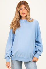 woman wearing a light blue oversized maternity sweatshirt with long sleeves and relaxed fit, no baby bump visible
