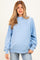 woman wearing a light blue oversized maternity sweatshirt with long sleeves and relaxed fit, no baby bump visible