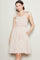 woman wearing a light pink floral sundress with tie shoulder straps and pockets