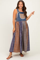 woman wearing a denim and plaid maternity dress with a fitted top and flowy skirt, showcasing a baby bump
