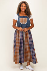 woman wearing a plus size denim overall dress with a plaid skirt and lace pocket detail