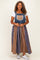 woman wearing a plus size denim overall dress with a plaid skirt and lace pocket detail