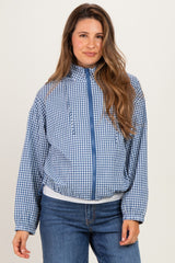woman wearing a blue checkered maternity jacket with a zipper and front pockets, styled with blue jeans