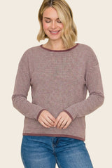 woman wearing a maroon and cream striped long sleeve sweater with a relaxed fit and round neckline