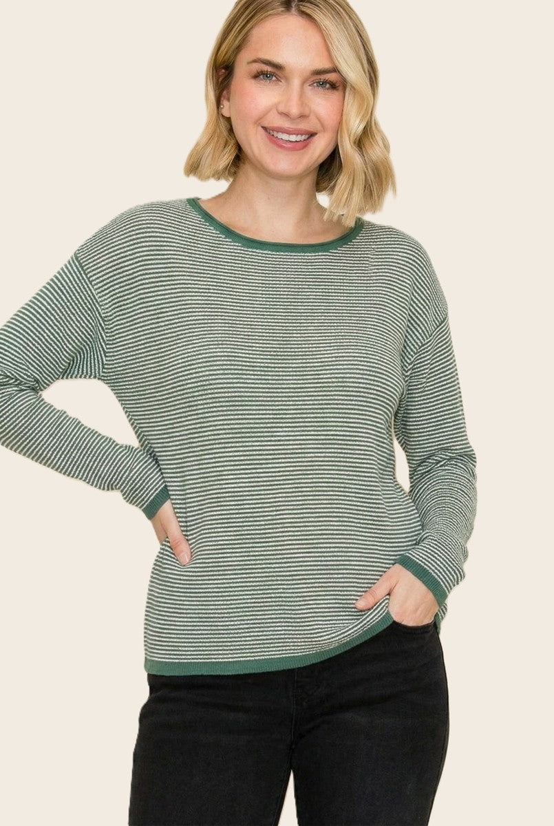 woman wearing a green and white striped long sleeve sweater with a round neckline and contrasting cuffs